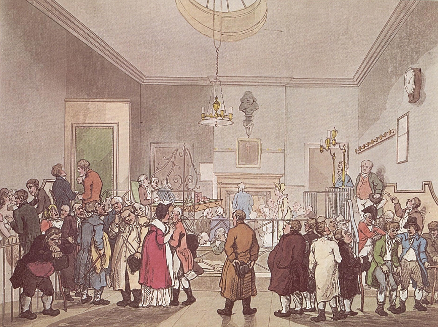 A view of the courtroom at Bow Street.  A raised desk with three men sitting behind it can be seen on the left, and a number of people, including a women, standing and addressing the magistrate can be seen in the middle of the court.  On the right, in a raised dock, a man in a blue coat can be seen.  In the foreground several groups of figures are standing talking. looking bored, or simply looking about them.  On the right a figure in leg irons is escorted by two men, one in military uniform.