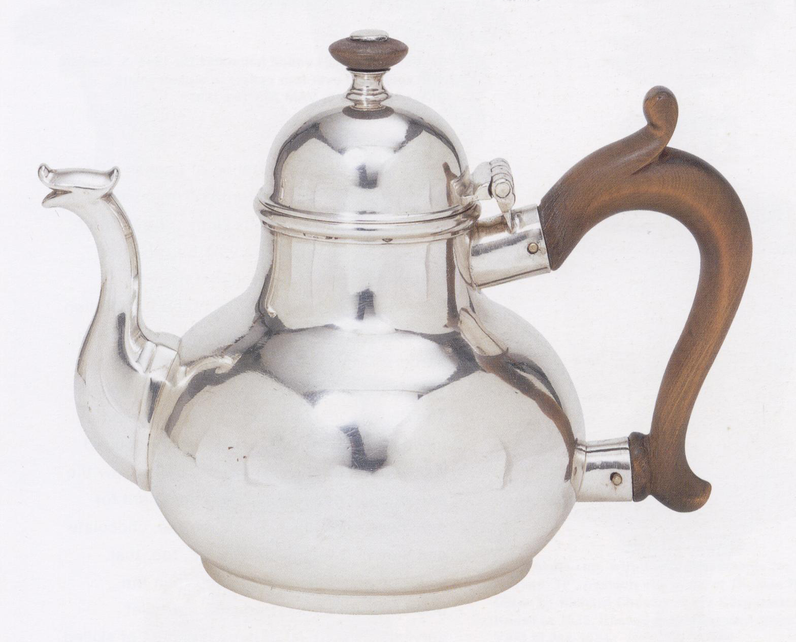 An English pear-shaped teapot in silver, with a wooden handle