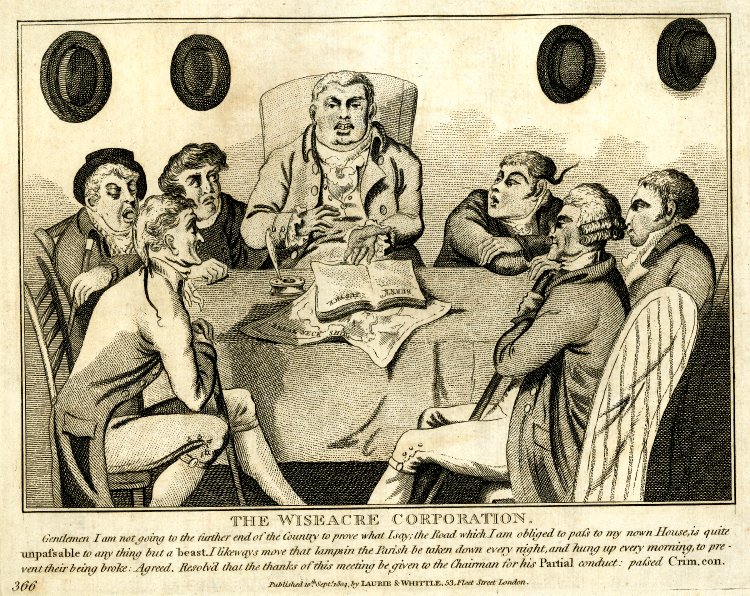 A group of well dressed men sit around a table deliberating, a book open in front of them.  The text below names them as the Wise Acre Corporation, and suggests they are discussing turnpikes and parish street lighting, and proposing that the lights should be taken down at night to avoid them being damaged.
